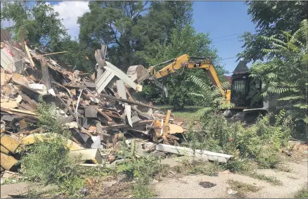  ?? RICHARD PAYERCHIN — THE MORNING JOURNAL ?? Workers from the Lorain Public Property Department demolish a house at 1823E. 29th St. in Lorain on July 20.