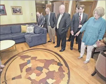  ?? Perry Bennett Associated Press ?? MEMBERS of the West Virginia House Judiciary Committee last week look at a $32,000 couch and a $7,500 wooden floor medallion in the office of state Supreme Court Justice Allen Loughry in Charleston.