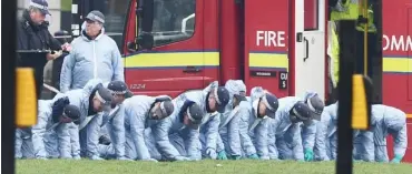  ?? Photo: AFP ?? Police in forensic suits search a grassed area in Parliament Square outside the Houses of Parliament in central London yesterday, the day after a terror attack in Westminste­r