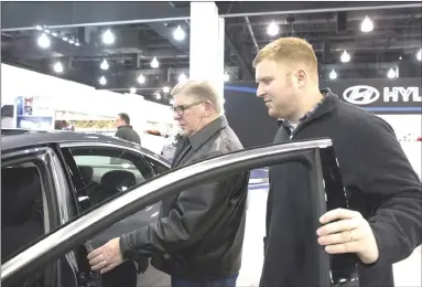  ?? Jeffrey Phelps photo ?? Bob Orzech Sr., left, and his son Bob Jr. check out cars at the 2015 Greater Milwaukee Auto Show.