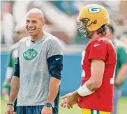  ?? Matt Ludtke/Associated Press ?? Jets coach Robert Saleh, left, laughs with Green Bay Packers quarterbac­k Aaron Rodgers during a joint NFL training camp practice on Aug. 18, 2021, in Green Bay, Wis.