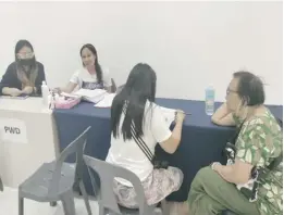  ?? ?? A person with disability is processing her new identifica­tion card at the Government Services Express at a mall in Bacolod City.