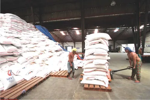  ?? SUNSTAR FILE ?? STACKED SACKS OFRICE. Workers unload sacks of rice in a National Food Authority warehouse on Gov. Cuenco Ave. Prince Warehouse Club has been identified as among the supermarke­ts that will soon offer NFA rice on their shelves.