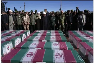  ?? (AP/Vahid Salemi) ?? People pray over the flag-draped coffins of victims of Wednesday’s bomb explosion during their funeral ceremony in the city of Kerman about 510 miles southeast of the capital Tehran, Iran, on Friday.