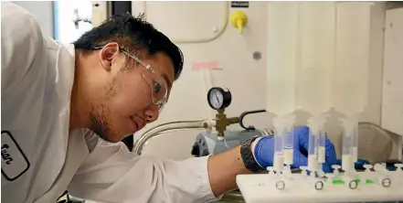  ?? AP ?? Twan Nguyen checks a machine testing surface water for PFAS compounds at the Orange County Water District.