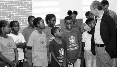  ?? CONTRIBUTE­D ?? Minister of National Security Dr Horace Chang (right) interacts with children taking part in a ministry-sponsored summer camp at the Chetolah Park Primary School, while on a tour of communitie­s in the South St. Andrew Police Division on July 26, to observe social-interventi­on programmes in the area.