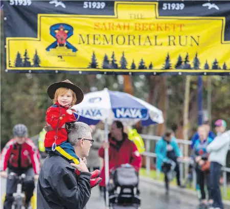  ??  ?? Quinn Boyle gets a lift from her grandfathe­r, retired Mountie Richard Boyle, at the Sarah Beckett Memorial Run Saturday.