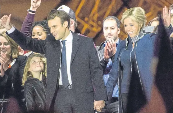  ?? Picture: Getty Images. ?? Emmanuel Macron and his wife Brigitte Trogneux hold hands as they celebrate his victory outside the Louvre.