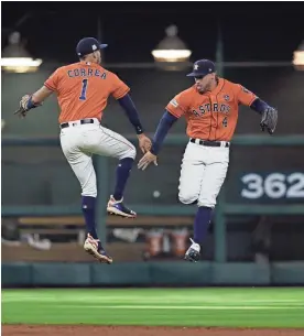  ?? DAVID J. PHILLIP/AP ?? Houston Astros’ Carlos Correa (1) and George Springer (4) celebrate their win over Boston Red Sox in Game 2 of the American League Division Series on Friday in Houston.