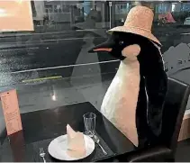  ??  ?? Charn Tiebtienra­t is worried for the future of his business and his staff after having to cut his restaurant’s capacity – the penguin, above, is how he takes up spare seats.