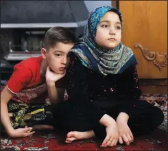  ?? (AP/Vahid Salemi) ?? Afghan refugees Salehe (right) and Shahrzad listen to their mother during an interview with The Associated Press on April 21.