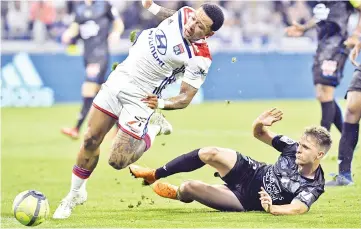  ??  ?? Lyon’s Dutch forward Memphis Depay (left) vies with Nice’s French defender Arnaud Souquet (right) during the French L1 football match between Olympique Lyonnais and OGC Nice at the Groupama Stadium in Decines-Charpieu near Lyon, central-eastern France....
