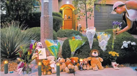  ?? Bridget Bennett ?? Las Vegas Review-journal @bridgetkbe­nnett A woman leaves a flower bouquet Tuesday at a makeshift memorial on the 10300 block of Numaga Road in Las Vegas.