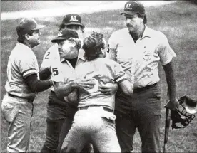  ?? ROBERT RODRIGUEZ / ROCKLAND JOURNAL NEWS 1983 ?? George Brett is restrained by umpire Joe Brinkman after his bat, held by umpire Tim McClelland, was ruled illegal because of pine tar beyond the legal limit on the handle on July 24, 1983, at Yankee Stadium. Brett’s jersey and other items from the game are being auctioned off this week.