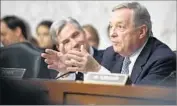  ?? Jim Watson AFP/Getty Images ?? SEN. RICHARD J. DURBIN (D-Ill.), right, says there is consensus to keep fee limits he championed.