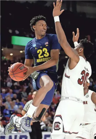  ?? GETTY IMAGES ?? Marquette’s Jajuan Johnson looks to pass around South Carolina’s Chris Silva on Friday. Johnson finished with 16 points on 5-for-9 shooting off the bench.