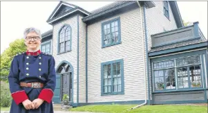  ?? MILLICENT MCKAY/JOURNAL PIONEER ?? Katherine Dewar wears a replica of the nursing uniform Georgina Fane Pope designed for the Canadian Army Nursing Core. The house in the background was the last residence Pope had in Summerside, where she lived with her mother and other family members....