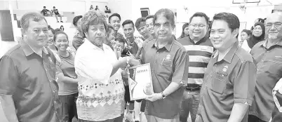  ??  ?? Awang Sham (second right) presents a memento to a sepaktakra­w team during a the meet-the-players session. Also seen is Karim (right).