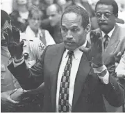  ?? SAM MIRCOVICH/REUTERS ?? O.J. Simpson, wearing the bloodstain­ed gloves entered into evidence in his murder trial is Los Angeles, displays his hands to the jury at the request of a prosecutor on June 15, 1995.