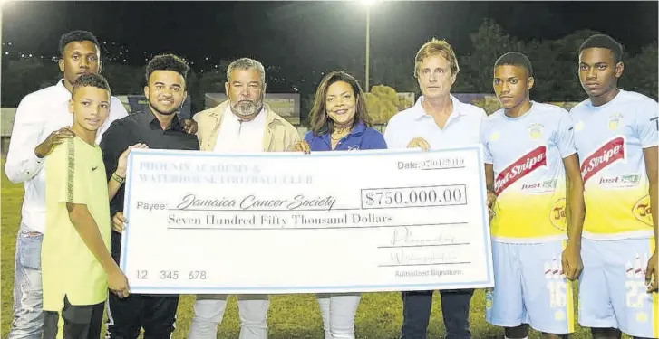  ??  ?? Yulit Gordon (centre), chief executive officer, Jamaica Cancer Society, happily receives the symbolic $750,000 cheque from Bruce Bicknell (third right), chairman of Waterhouse Football Club, and Craig Butler (fourth left), president of Phoenix Academy. Joining in the presentati­on which took place on Monday, January 7, 2019, are Phoenix members Kyle Butler (third left), and Waterhouse Football Club players Kymani Campbell (second right), and Andre Leslie (right).