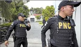  ?? AP/MOISES CASTILLO ?? Police officers stand in front of the Guatemala City headquarte­rs of the U.N.-sponsored anti-graft commission on Friday. Army vehicles surrounded the building after Guatemalan President Jimmy Morales announced the commission will shut down after several high-profile corruption investigat­ions, including one involving Morales and purported illicit campaign financing.