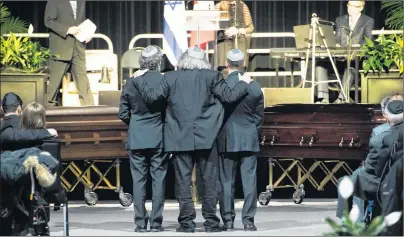  ?? CP PHOTO ?? People look on as the caskets get ready to leave during a memorial service for Apotex billionair­e couple Barry and Honey Sherman in Mississaug­a, Ont., Thursday. Seventy-five-year-old Barry Sherman and his 70-year-old wife Honey were found dead in their...
