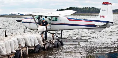  ??  ?? Sacks of wild rice are loaded by bush pilot Joel Cook onto a plane at Montreal Lake. Provincial regulation­s stipulate that only northern residents can hold leases on lakes where wild rice grows.