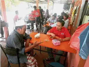  ??  ?? Homecoming: Wan Saiful speaking with a local resident on the campaign trail in Pendang.