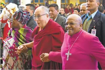  ?? ASHWINI BHATIA AP ?? Archbishop Desmond Tutu (right) and Tutu’s wife, Leah, join hands with Tibetan spiritual leader the Dalai Lama in Dharmsala, India, in 2012. Tutu and the Dalai Lama both received the Nobel Peace Prize.