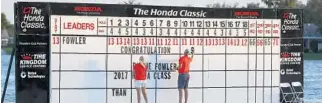  ?? WILFREDO LEE/AP ?? Volunteers put up a congratula­tory note on the leaderboar­d on the 18th hole after Rickie Fowler won the Honda Classic on Sunday.