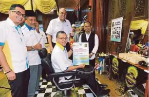  ?? HAFIZUDIN MOHD SAFAR
PIC BY ?? Perlis Menteri Besar Datuk Seri Azlan Man (seated) and Northern Corridor Implementa­tion Authority chief executive Datuk Redza Rafiq (second from right) with a recipient of the MCash grant, barber Sarizan Hamid (right), in Kangar yesterday.