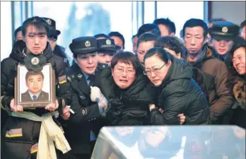  ?? GUO LIANG / FOR CHINA DAILY ?? Zhao Tianyu’s daughter (left) and wife (third from left) mourn at Zhao’s memorial service in Tonghua, Jilin province, on Tuesday.