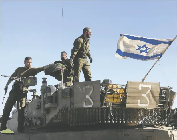  ?? MENAHEM KAHANA / AFP VIA GETTY IMAGES ?? Israeli soldiers check a gun atop a military vehicle on the border with the Gaza Strip on Sunday. The Israeli military says its defences in the area
are being ramped up.