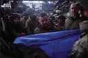  ?? UKRAINIAN PRESIDENTI­AL PRESS OFFICE VIA AP ?? Ukrainian President Volodymyr Zelenskyy signs a Ukraine national flag at the site of the heaviest battles with the Russian invaders in Bakhmut, Ukraine on Tuesday.