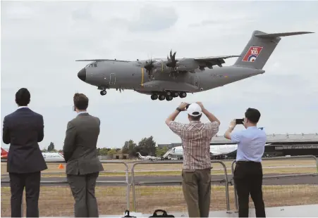  ?? AP PHOTOS ?? TOUCHING DOWN: An Airbus 400M, above, lands after a flying display at the Farnboroug­h Internatio­nal Airshow in England. British Prime Minister Theresa May, below second from left, speaks with Airbus CEO Tom Enders, right.