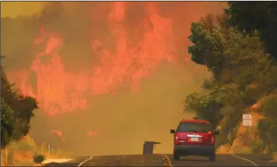  ?? Mike Eliason/AP ?? Wildfires: This Saturday, July 8, photo released by the Santa Barbara County Fire Department shows a Santa Barbara City Fire vehicle on Highway 154 in the Whittier fire east of Cachuma Lake in Santa Barbara County, Calif.