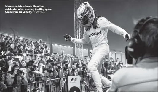  ?? Photo: VCG ?? Mercedes driver Lewis Hamilton celebrates after winning the Singapore Grand Prix on Sunday.