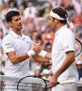  ??  ?? Djokovic e Federer al termine dell’epica finale di Wimbledon del 2019 vinta dal serbo