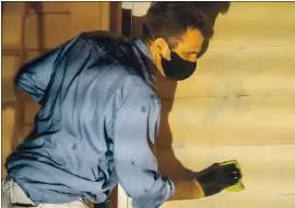  ?? DYLAN BOUSCHER — STAFF PHOTOGRAPH­ER ?? San Jose Mayor Sam Liccardo washes spray-painted messages off the exterior of his house in San Jose on Friday. Liccardo got some help from neighbors.