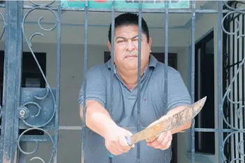  ??  ?? Francisco Alfonso Velázquez Brindis, vendedor de bienes raíces de 54 años de edad, ha tenido que aprender a disparar un arma y a manejar el machete para defenderse de los delincuent­es.