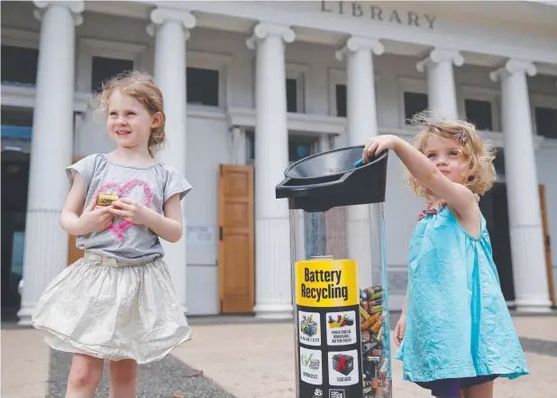  ?? Picture: BRENDAN RADKE ?? CLEAN AND GREEN: Redlynch sisters Bailey and Bonnie Gibbs recycle batteries at the Cairns City Library while visiting with their grandparen­ts.