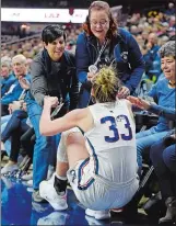  ?? SEAN D. ELLIOT/THE DAY ?? UConn fans Marie Croteau, left, and Sharon Rastello, from Methuen, Mass, help Katie Lou Samuelson to her feet after going out of bounds chasing a loose ball against South Florida in the second half of Sunday’s AAC game at Gampel Pavilion in Storrs. UConn won 63-46.