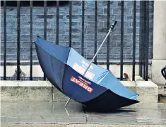  ??  ?? Eye of the storm: an umbrella is left to the elements outside Downing Street