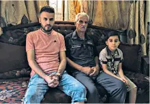  ??  ?? Walid Ibrahim Khalil, 46, sits with his sons Khaled, 27, and Mohammed, 10