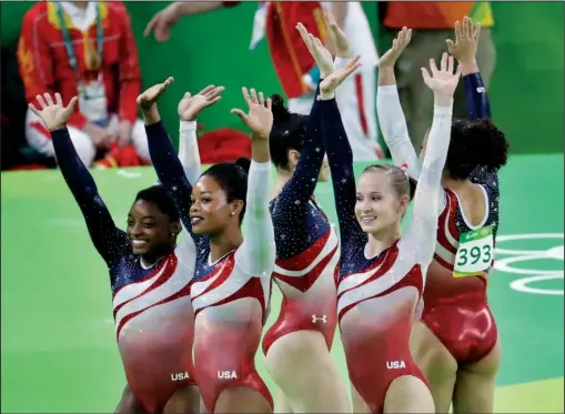  ??  ?? GOLDEN GIRLS: U.S. gymnasts, left to right, Simone Biles, Gabrielle Douglas, Aly Raisman, Madison Kocian and Lauren Hernandez wave to the audience after winning the gymnastics women’s team gold medal Tuesday in Rio de Janeiro. The Americans...