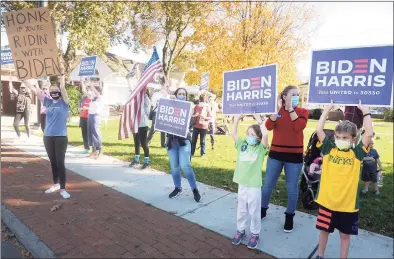  ?? Ned Gerard / Hearst Connecticu­t Media ?? Above and below, people came to the Sherman Green in Fairfield Saturday afternoon to cheer to passing motorists after it was announced that Joe Biden had defeated President Donald Trump in the 2020 presidenti­al election.