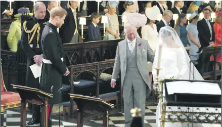  ??  ?? Prince Harry looks at his bride, Meghan Markle, as she arrives accompanie­d by his father Prince of Wales.