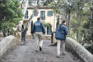  ?? Photograph­s by Michael Owen Baker For The Times ?? FEDERAL OFFICIALS Jerry Grigsby and Melinda Roussos check a residence in Montecito, Calif. The area did sustain light damage from an arctic storm Friday, but mandatory evacuation­s were lifted early in the day.