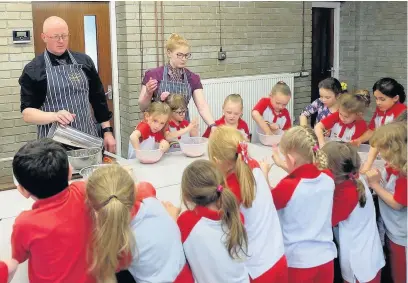  ??  ?? Clayton-le-Moors Rainbows get stuck in to sausage making