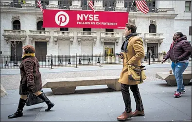  ?? Bloomberg News/MICHAEL NAGLE ?? Pedestrian­s pass the New York Stock Exchange, where on Friday the Dow Jones industrial average sank 500 points in the afternoon but ended the day with a gain of 330 points.
